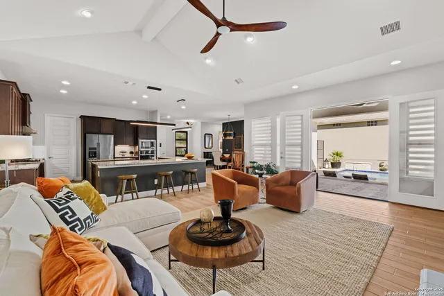 a living room with furniture kitchen view and a wooden floor