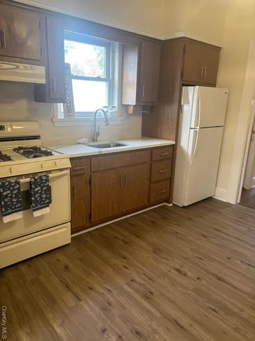 a kitchen with a refrigerator sink and wooden floor