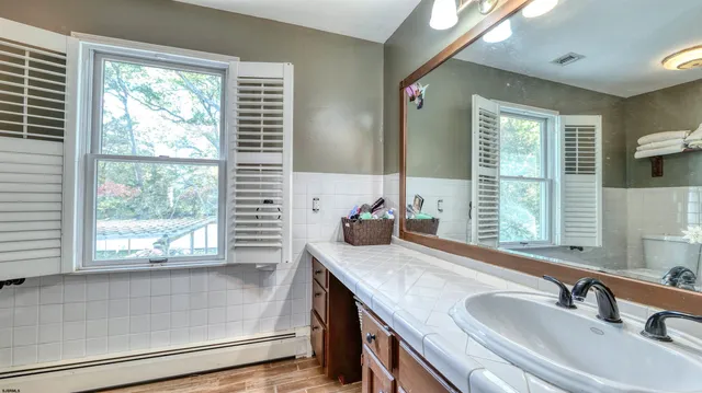 a bathroom with a granite countertop sink and a window