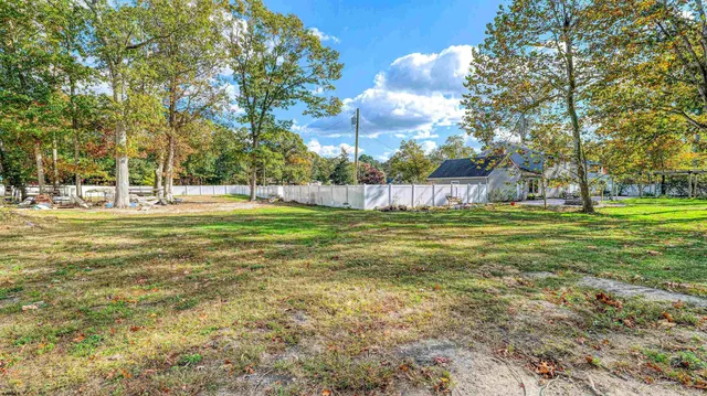 a view of a park with houses and trees in the background