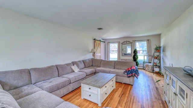 a living room with furniture and a wooden floor