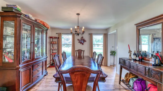 a dining room with furniture a chandelier and wooden floor