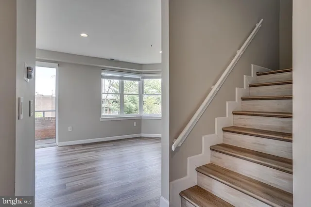 a view of staircase with wooden floor and fan