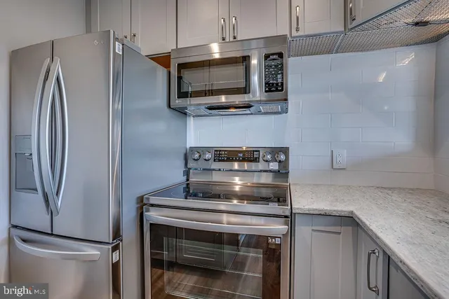 a stove top oven sitting inside of a kitchen
