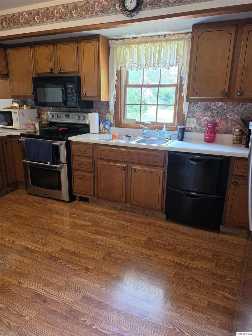 103 East Spring Street Camp Point, IL 62320 - Photo 2 of 8 a kitchen with stainless steel appliances granite countertop a stove a sink and a microwave