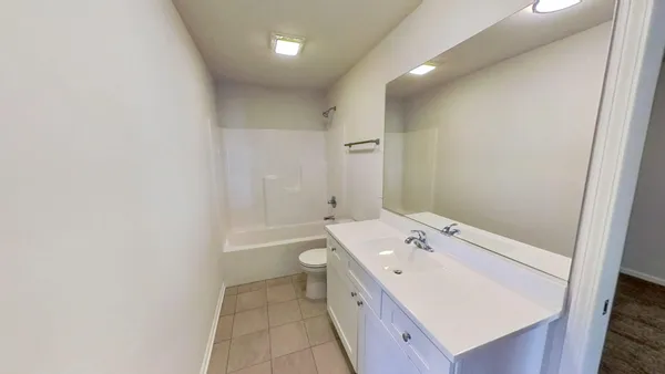 a spacious bathroom with a tub sink and mirror