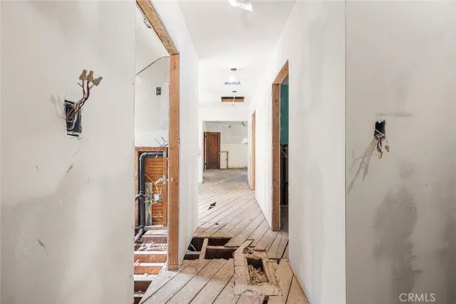 a view of a bedroom with wooden floor and windows