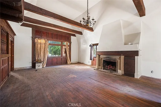 a view of an empty room with a fireplace and a chandelier