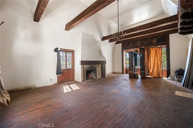 a view of a livingroom with wooden floor and a fireplace