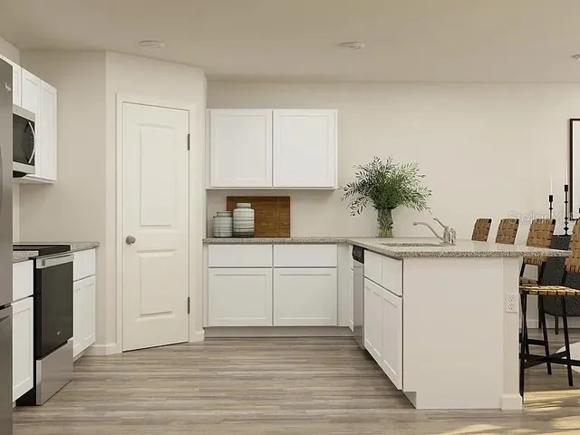 a kitchen with a sink cabinets and wooden floor