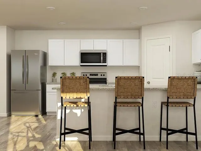 a kitchen with a refrigerator and a stove top oven