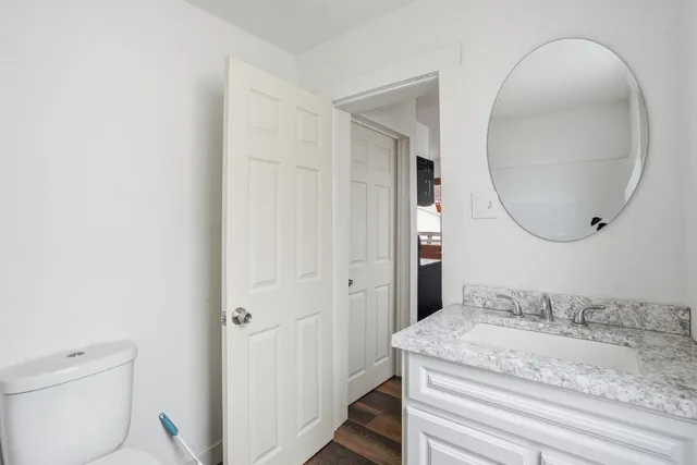 a en suite bathroom with a granite countertop sink and a mirror