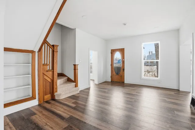 a view of an entryway with wooden floor and door