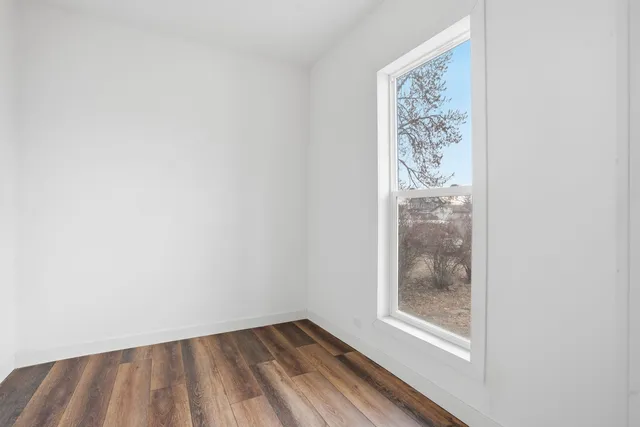 a view of a small space with wooden floor and a window