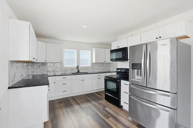 a kitchen with stainless steel appliances a refrigerator sink and microwave