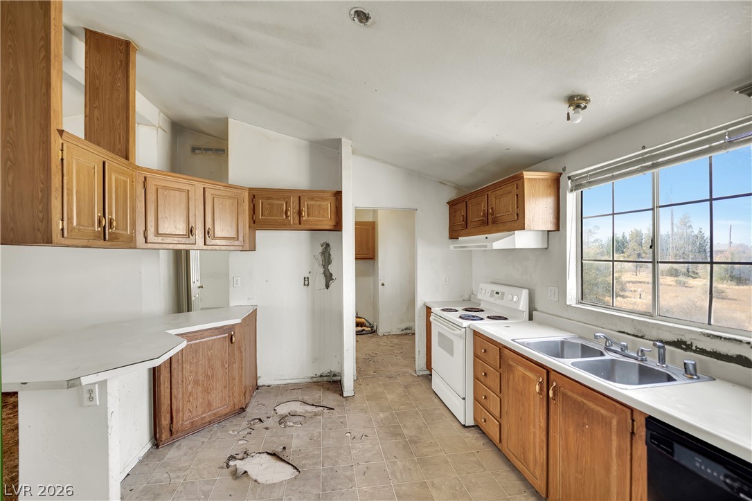 4361 Maple Road Pahrump, NV 89048 - Photo 14 of 46 A utilitarian kitchen awaiting a modern transformation with a window overlooking the landscape.