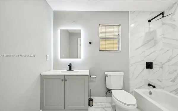a bathroom with a sink toilet vanity and tub