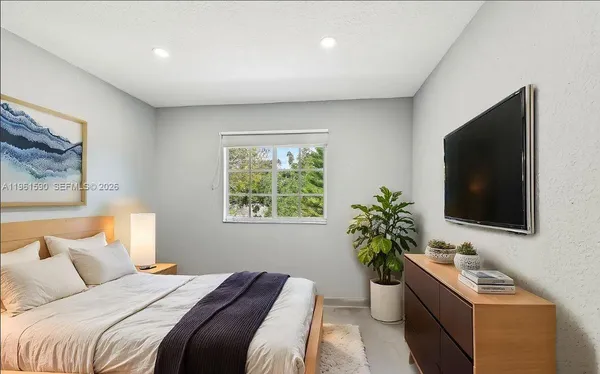 a bedroom with a bed and a flat screen tv