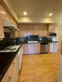 a kitchen with granite countertop a refrigerator and a sink