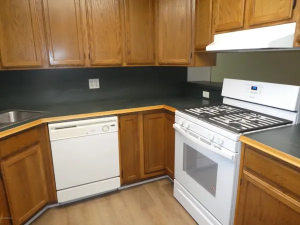 a kitchen with granite countertop white cabinets and white appliances