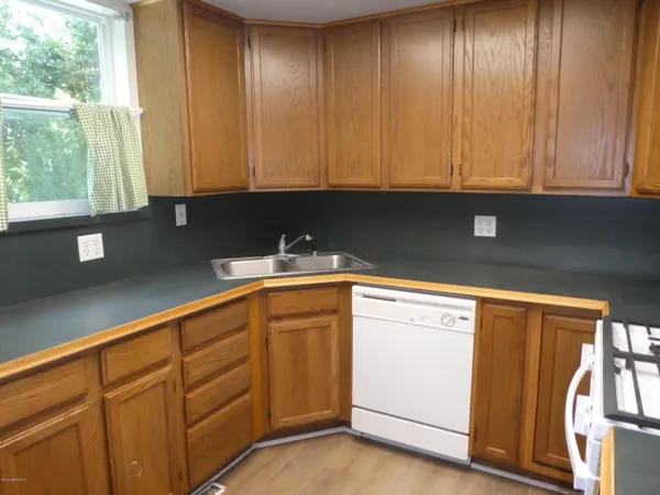 a kitchen with granite countertop cabinets stainless steel appliances a sink and window