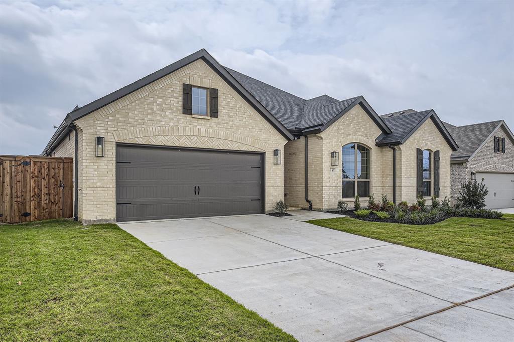 167 Sandie Drive Rhome, TX 76078 - Photo 2 of 29 French country inspired facade with brick siding, concrete driveway, a garage, and roof with shingles