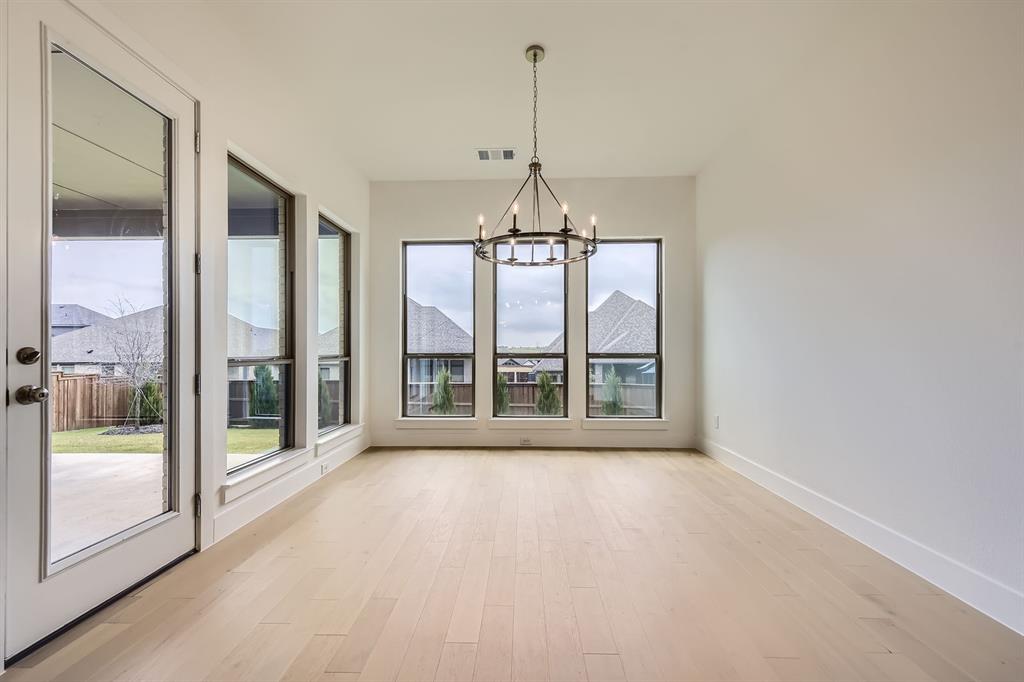 167 Sandie Drive Rhome, TX 76078 - Photo 7 of 29 Unfurnished dining area featuring a chandelier, light wood finished floors, and baseboards
