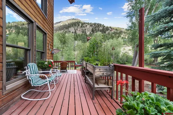 a view of a balcony with wooden floor and outdoor seating