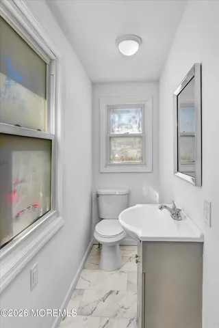 a bathroom with a toilet sink and mirror