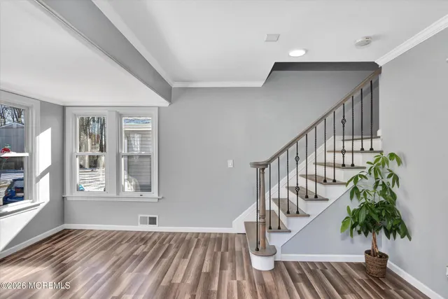a view of entryway with wooden floor and stairs