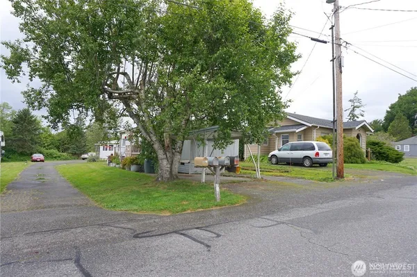 a view of a house with a big yard and large trees