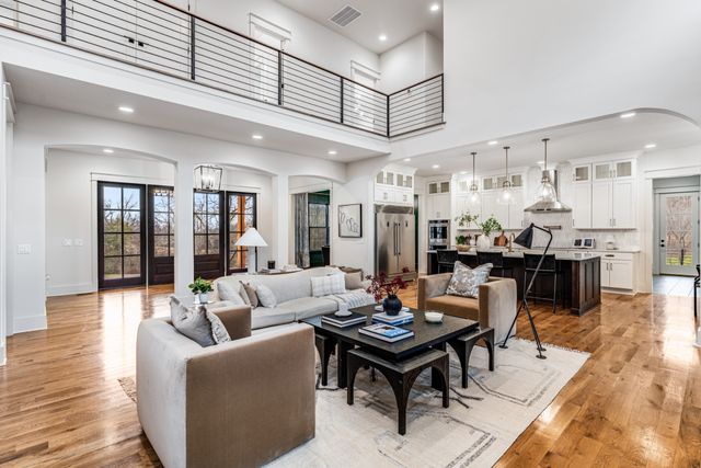a living room with lots of furniture and kitchen view