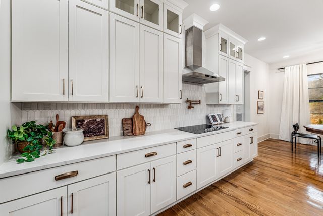 a kitchen with stainless steel appliances granite countertop a sink a stove and cabinets