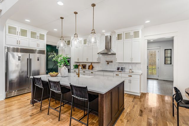a kitchen with stainless steel appliances kitchen island a table and chairs in it