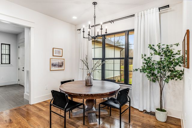 a dining room with furniture potted plants and wooden floor