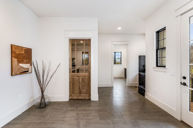 a view of a hallway with wooden floor and a living room