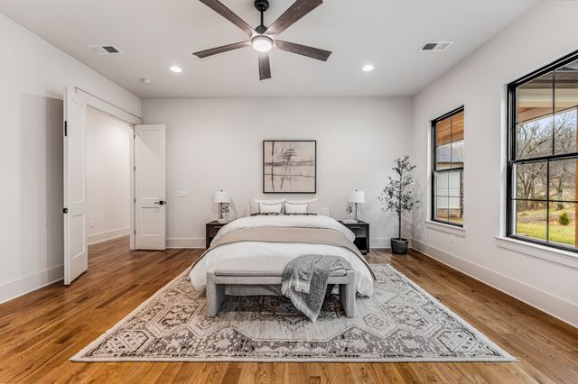 a bed sitting in a spacious bedroom next to a window