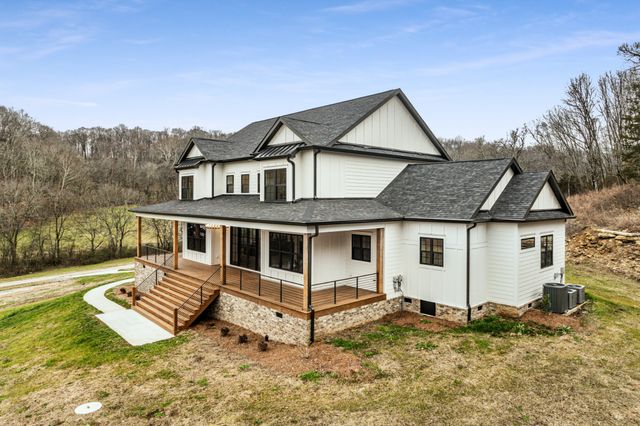 a view of a house with a yard and fence