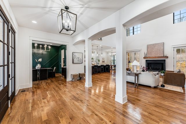 a view of a livingroom with furniture a chandelier and wooden floor