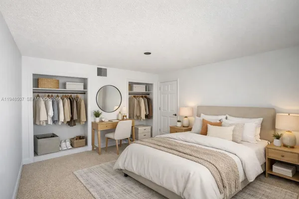 a bedroom with a bed a mirror and a large window
