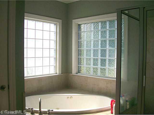 5700 Mabe Drive Oak Ridge, NC 27310 - Photo 12 of 16 Master Bath/Spa. Master bath enjoys large jetted tub, spacious separate shower, double vanity and his and hers closets. Beautiful and bright