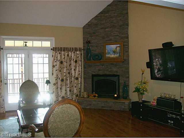 5700 Mabe Drive Oak Ridge, NC 27310 - Photo 6 of 16 Den/Family/Great Room. Elegant yet comfortable den offers corner fireplace with stone profile, volume ceiling with balcony. Opens to screened porch. Great for entertaining or for quiet down time. Includes wide-screen TV and speakers.