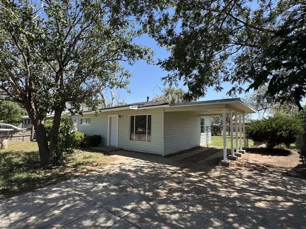 a view of a house with a large tree and a yard