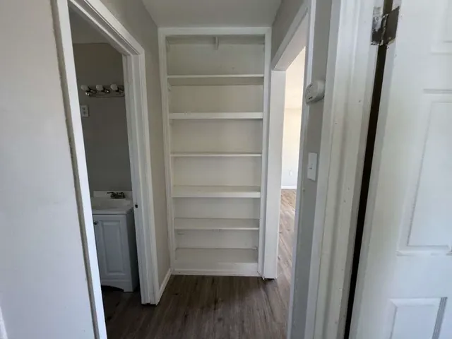 a view of walk in closet with empty racks