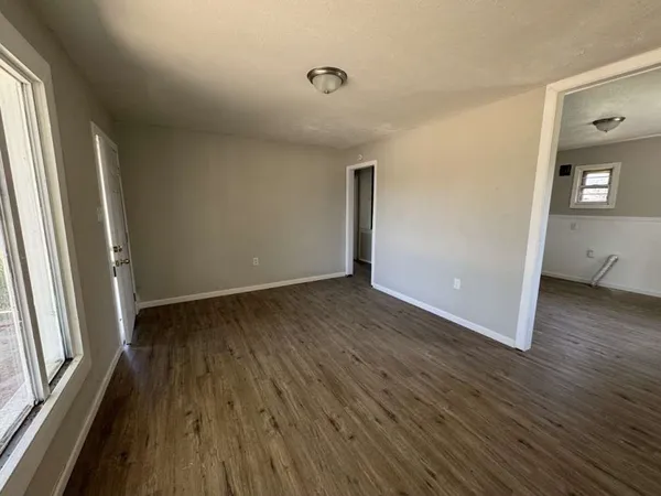 a view of a room with wooden floor and a window