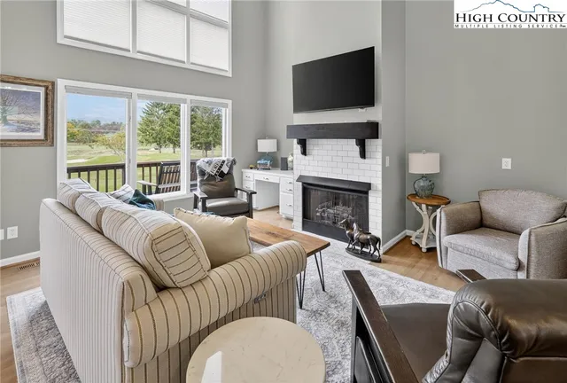 a living room with furniture a flat screen tv and a fireplace