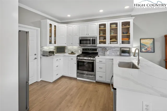 a kitchen with stainless steel appliances a stove sink microwave and cabinets