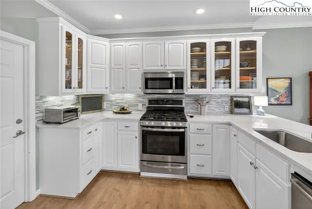 a kitchen with granite countertop a stove a sink and a microwave