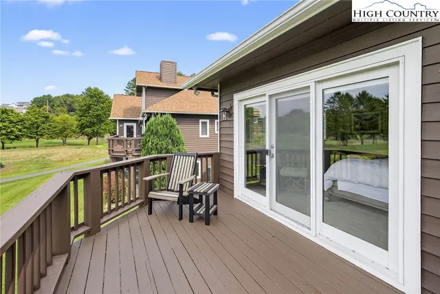 a view of a balcony with chairs and wooden floor