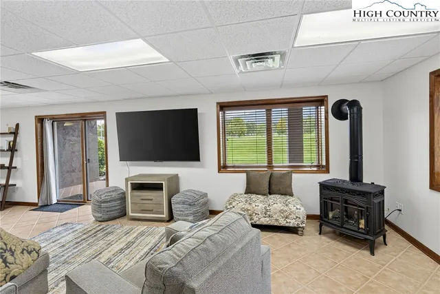 a living room with furniture a flat screen tv and a large window